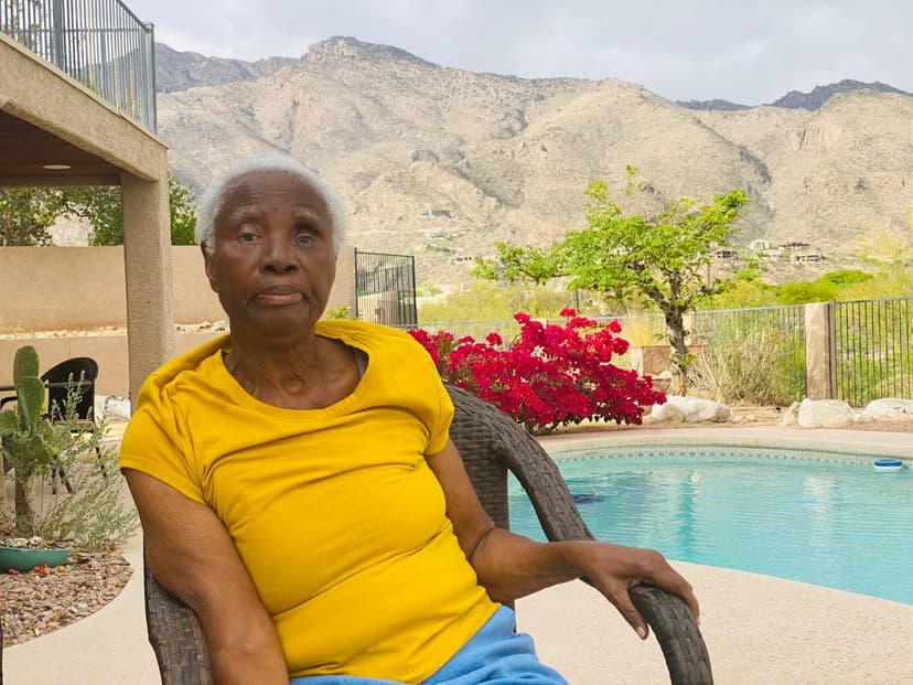 Mami in a yellow t-shirt by a pool, bougainvillea and mountain views